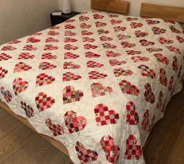 Smukt håndsyet sengetæppe med quiltet bladmotiv