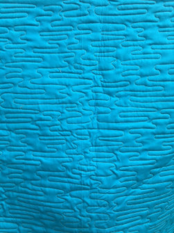 Håndsyet tæppe quiltet med bølgemønster - bagsiden