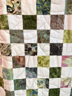Detalje billede af håndsyet tæppe quiltet med bladmotiv